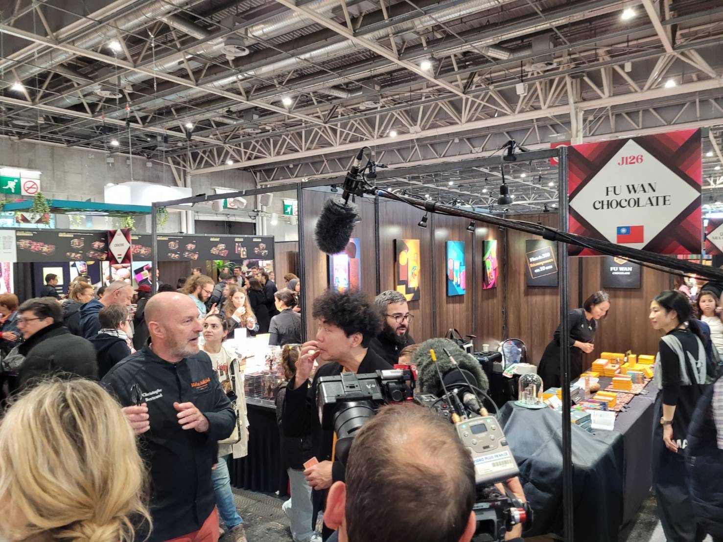 創辦人許華仁（中）於巴黎展位前受訪。圖/福灣巧克力提供