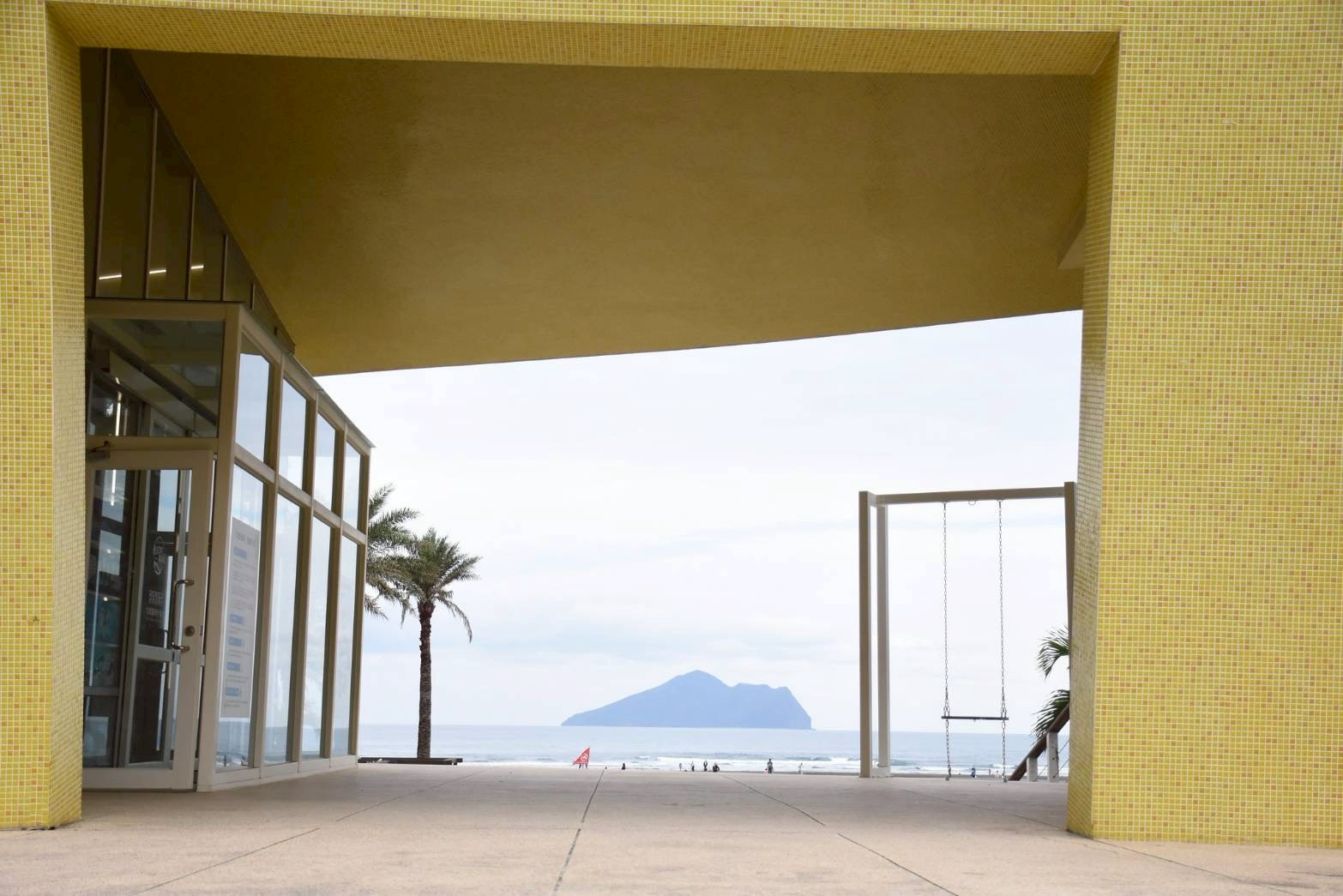 從建築框景望出去的龜山島，被海風吹拂的畫面寧靜舒心，成為旅人到東北角必拍的浪漫打卡點。圖/東北角風管處提供