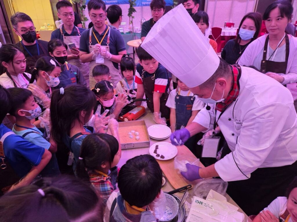 主廚江進華近距離示範「大寮紅豆麻糬包」等在地料理製作步驟,現場親子熱情參與。圖/高雄市農業局提供