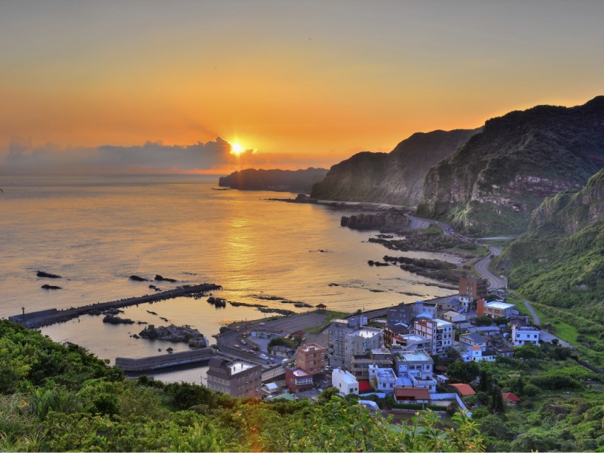 晨曦金光灑落於鼻頭角海岸與漁村,勾勒出東北角山海交會的寧靜與絕美景色。(圖/東北角及宜蘭海岸國家風景區管理處提供)