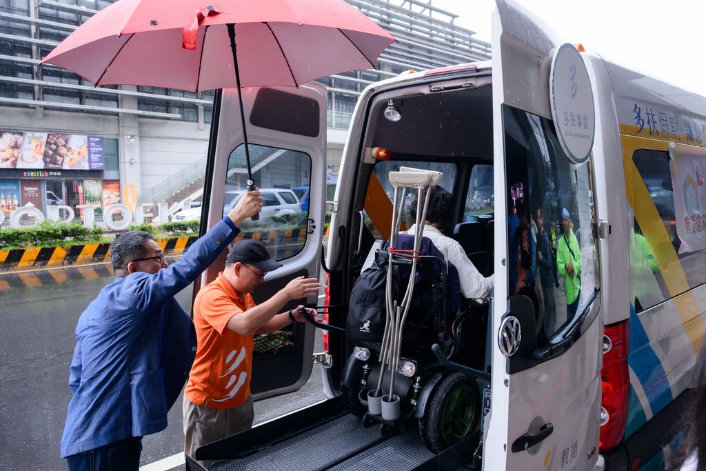 工作人員協助輪椅旅客搭乘有愛旅圖無障礙專車出發。圖/基隆市政府社會處提供